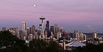 The moon rises over downtown Seattle at sunset.